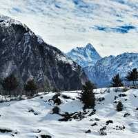 Snow-capped mountains with clouds overhead in Auli, India