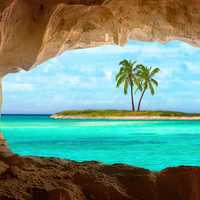 Viewing a tropical island and Palm tree through a cave
