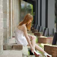 asian-girl-sitting-on-bricks-in-dress-and-high-heels