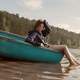 girl-sitting-in-canoe-with-feet-in-water-in-the-summer