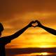 silhouette-of-mother-and-daughter-making-a-heart-with-hands-during-sunset