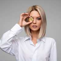 Woman holding Bitcoin up to eye