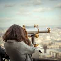 woman-looking-at-city-through-telescope