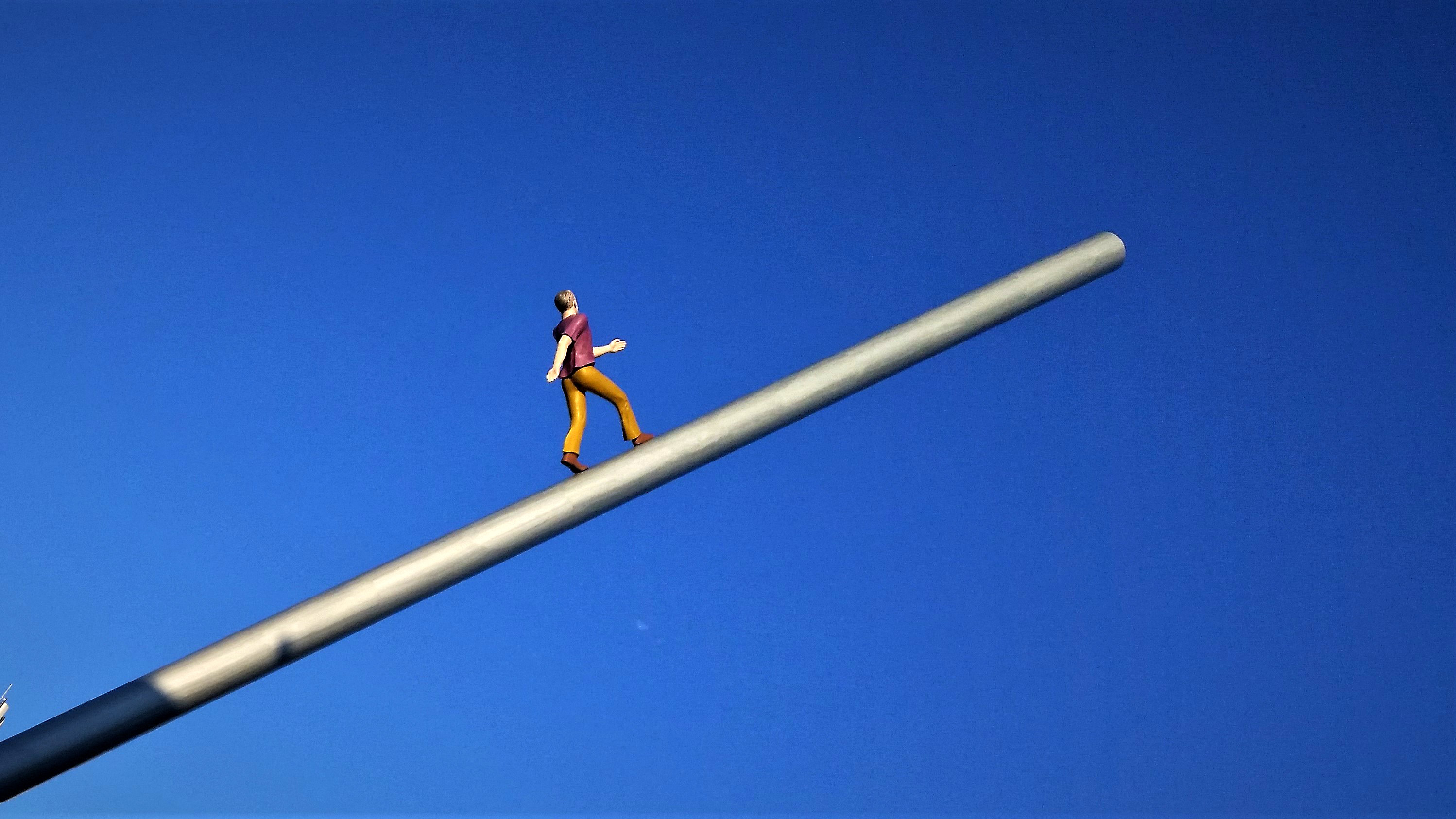 man-figure-walking-towards-sky-on-pole.jpg