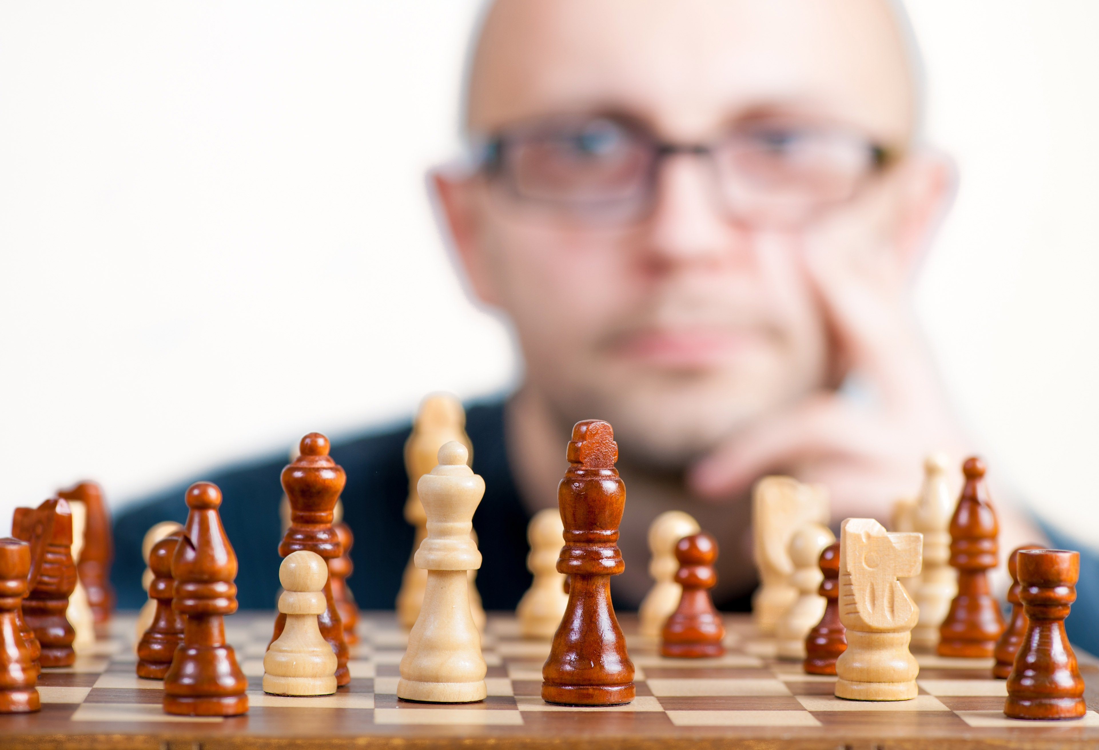 Serious man playing chess in studio · Free Stock Photo