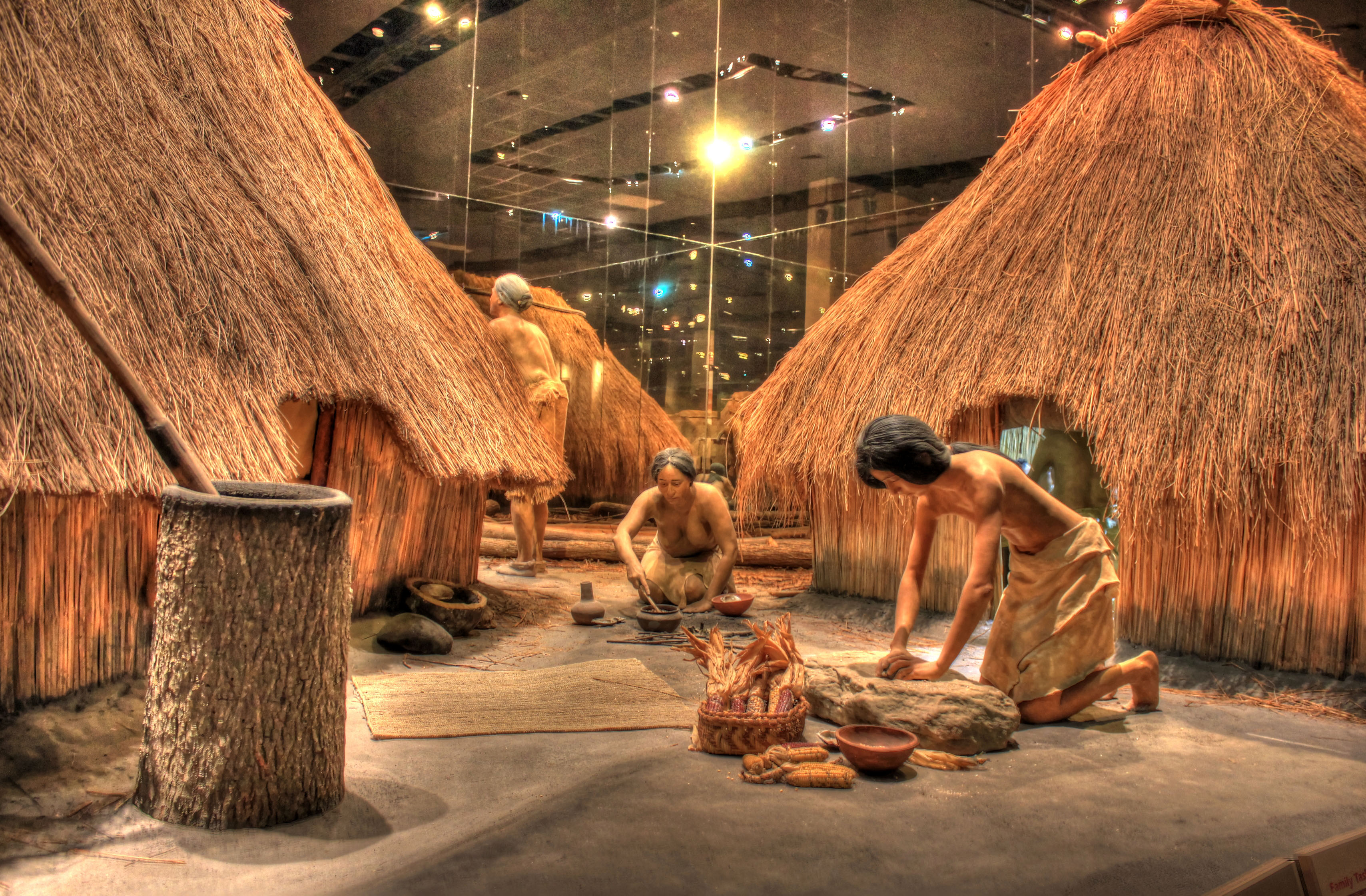 Native Americans working besides houses at Cahokia Mounds, Illinois