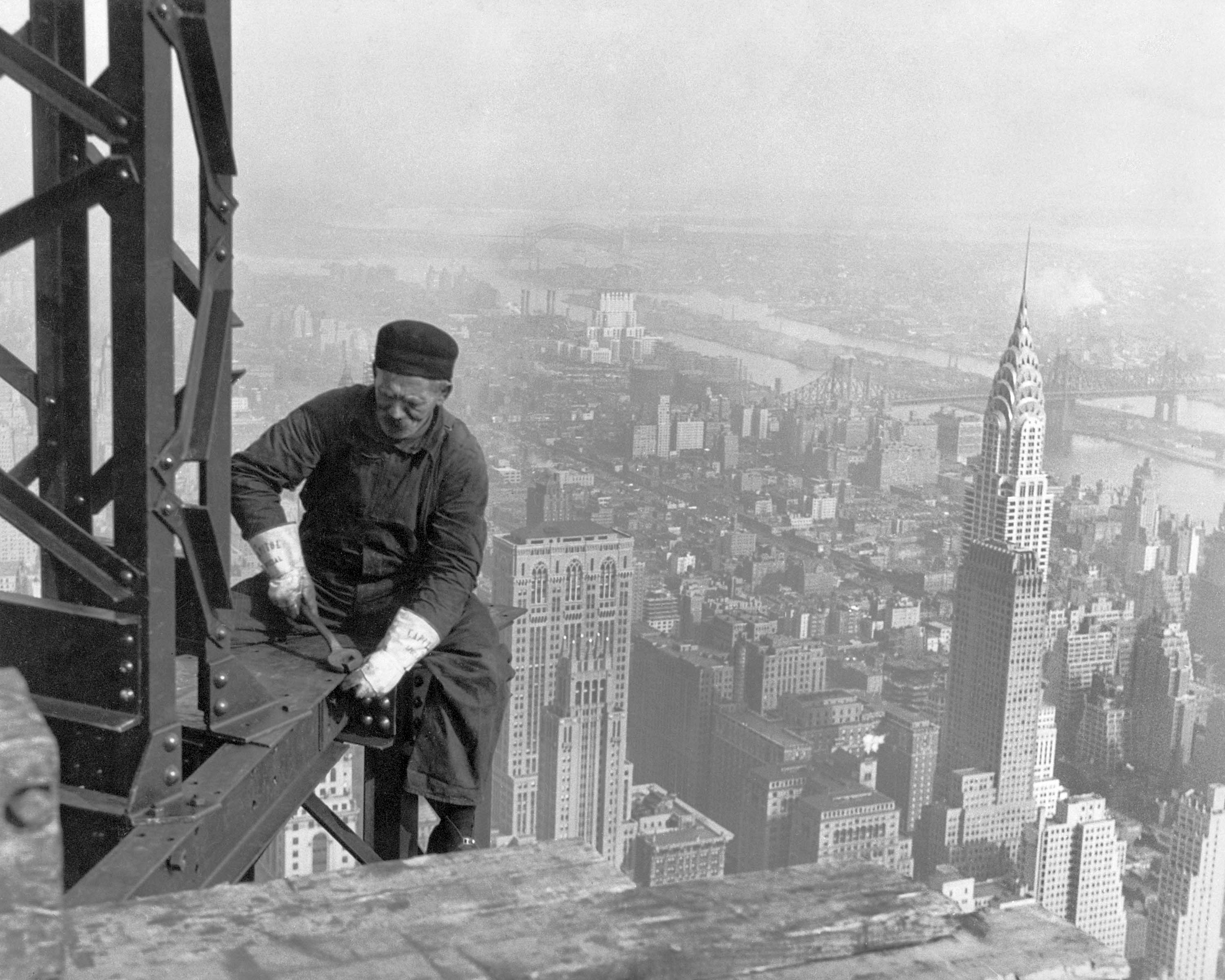 A construction worker on top of the Empire State Building as it was ...