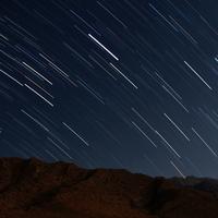 Star trails over the mountains in night sky