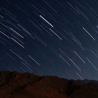 Star trails over the mountains in night sky