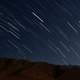 Star trails over the mountains in night sky