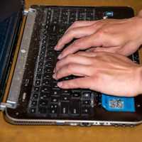 Hands Typing on Laptop