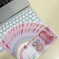 Macbook with a fan of chinese hundred dollar bills