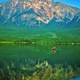 Canoeing in a emerald green lake in the Canadian Rockies