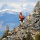 Man Climbing Rocky Mountain while playing Guitar