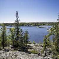 Looking at Vee Lake on a Clear Day with pine trees in Yellowknife