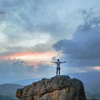 Boy standing on Mountain looking at clouds in Villa de Leyva