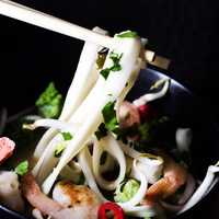 Chopsticks holding seafood noodles