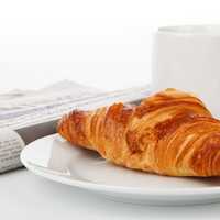 Croissant with tea and newspaper