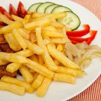 Fries on a plate with chicken and cucumbers 