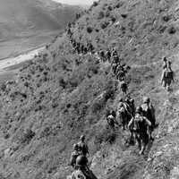 U.S. Marines move out over rugged mountain terrain during Korean War
