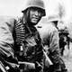 German machine gunner marching through the Ardennes in the Battle of the Bulge