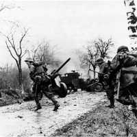 German troops advancing past abandoned American equipment during the Battle of the Bulge