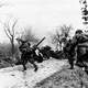 German troops advancing past abandoned American equipment during the Battle of the Bulge