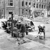 German women washing clothes at a cold water hydrant in a Berlin street, World War II