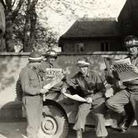 US military policemen read about the German surrender ending World War II in Europe