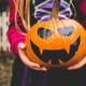 Girl holding Jack-O-Lantern Halloween Pumpkin scary face