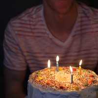 Person holding Birthday Cake with four candles