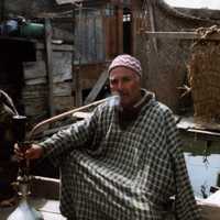 Kashmiri man smoking a traditional hookah pipe in Srinagar, Kashmir, India