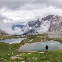 Male hiker in the Italian Dolomites Mountains overlooking a lake