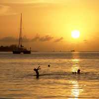 Sunset over the ocean with two people playing in Jamaica