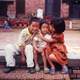 Two kids hugging a smaller kid in Kathmandu, Nepal