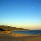 Beach landscape with moon in blue sky