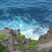 Blue Water Waves Crashing onto rocky shoreline