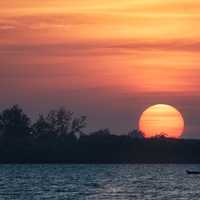 Dusk and sunset over the river with large sun