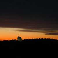 Dusk landscape with tower and flag