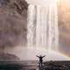 Man Standing Beneath the Waterfall and Double Rainbow
