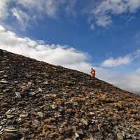 Man going up rocks on a hillside