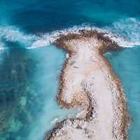 Ocean Waves crashing on small island aerial view