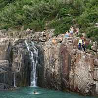 People swimming under the waterfall