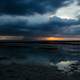 Seashore and water under stormy skies 