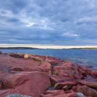 Seaside landscape with red rocks and sky