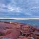 Seaside landscape with red rocks and sky