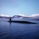 Submarine surfacing with mountains in the landscape