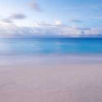 Beach, sand and Ocean with sky and clouds background