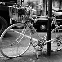 Black and White photo of Bicycle leaning on post