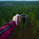 Holding a Cup over the forest